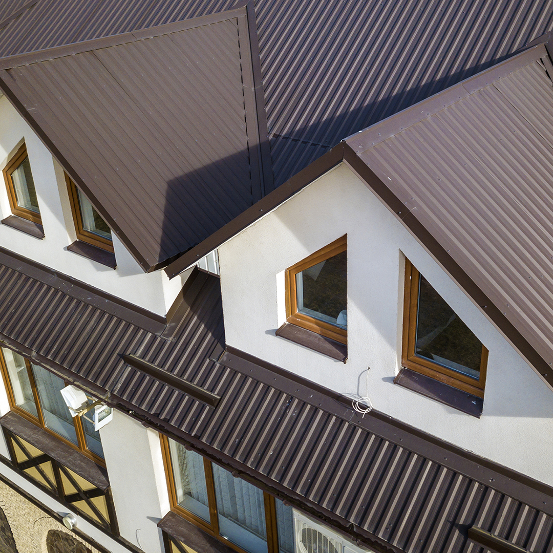 Aerial shot of a white home with a dark colored metal roof