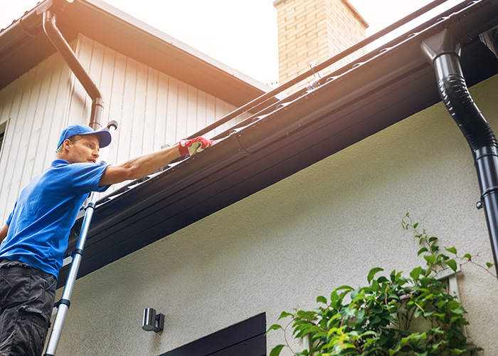 Image of a man fixing gutter